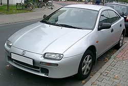 Mazda - 323 F - 5 drzwi - (1994 - 1998) - Osprzęt / Zbiorniczek spryskiwaczy